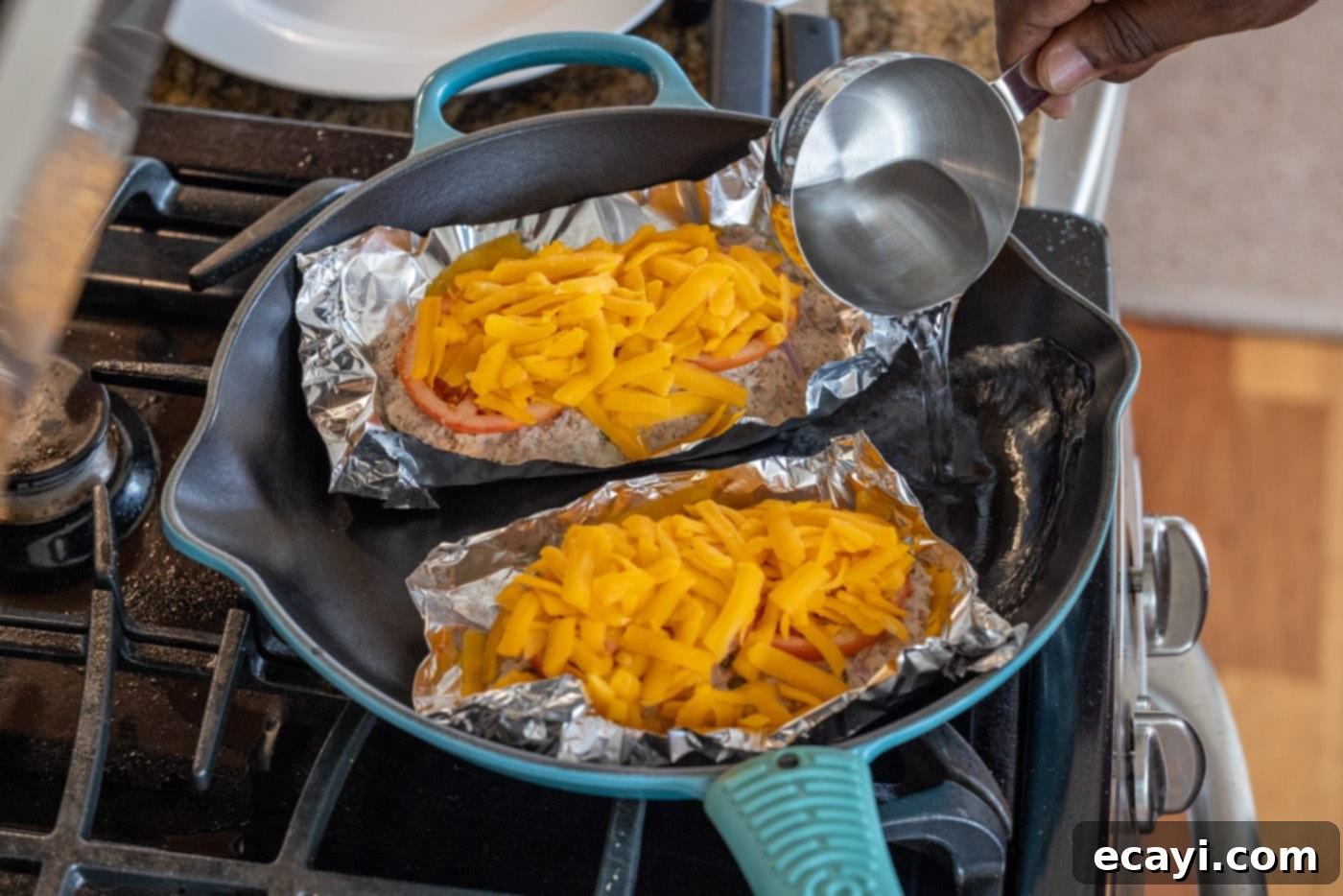 Golden Tuna Grille 8 A skillet with tuna salad and cheese in foil bowls, with a small amount of water added to the pan for steaming.