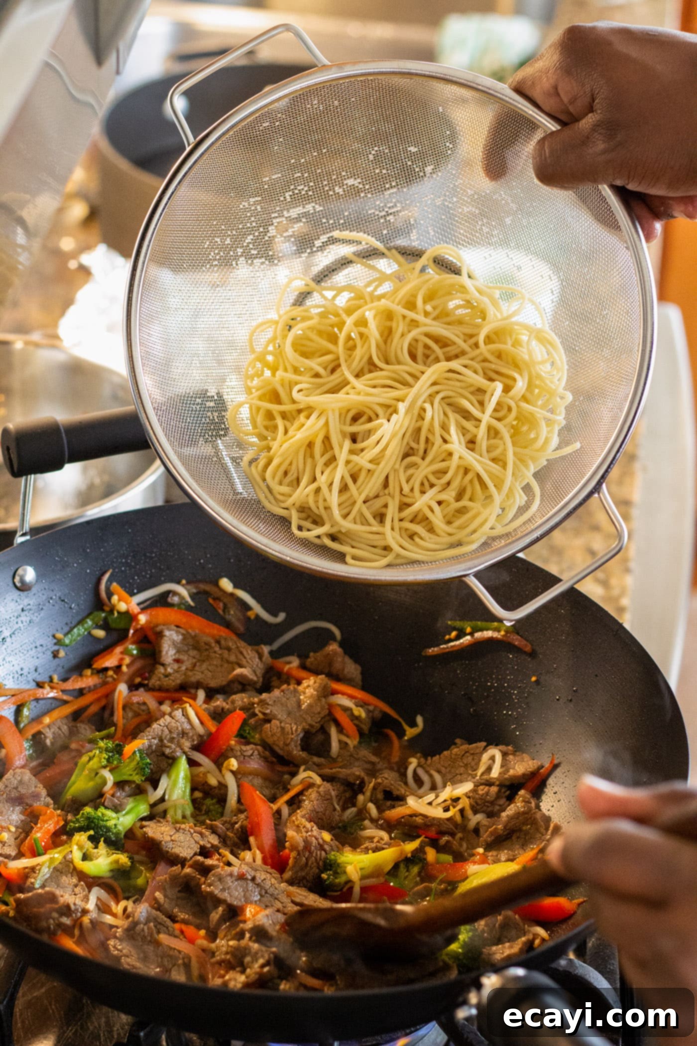 Ultimate Beef Lo Mein 13 adding lo mein noodles to stir fry