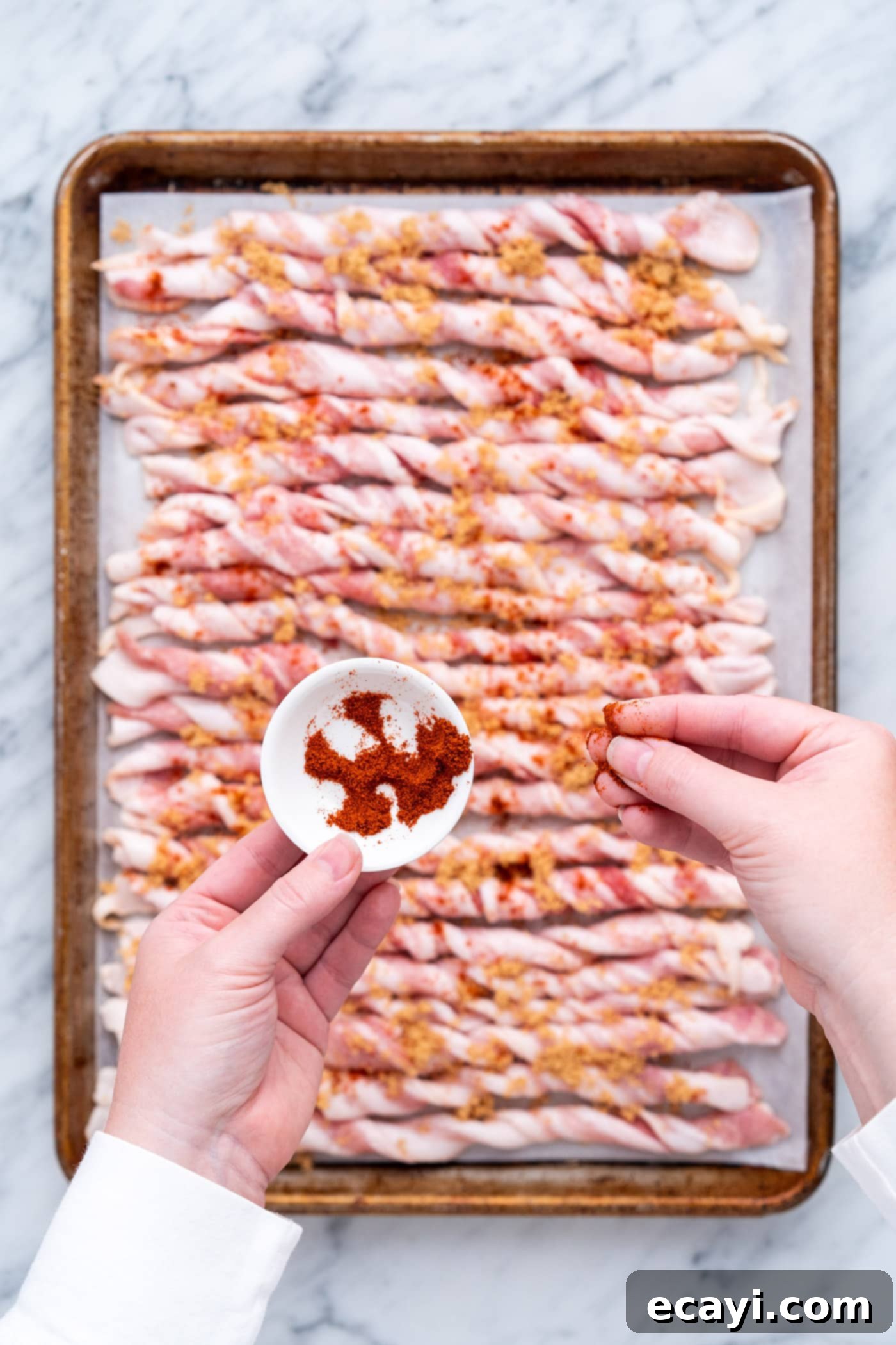 Crispy Bacon Spirals 8 Evenly sprinkling cayenne pepper onto the seasoned bacon twists