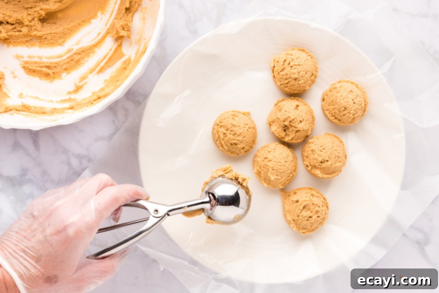 Sweet & Salty Fluffernutter Delights 13 scooping peanut butter cookie dough into balls on a plate for chilling