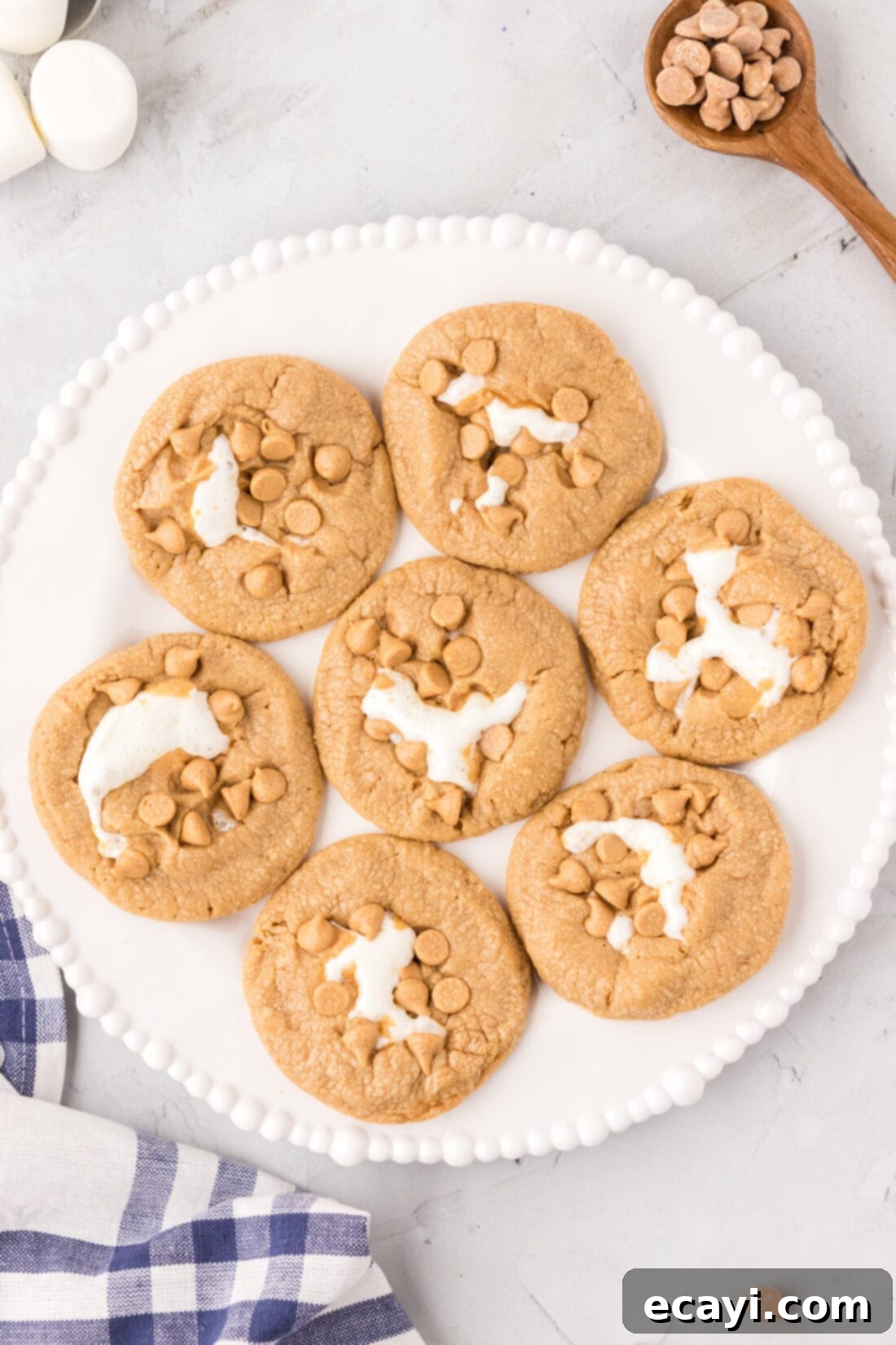 Sweet & Salty Fluffernutter Delights 21 plate of Fluffernutter Cookies with one cookie pulled apart to show the melted marshmallow