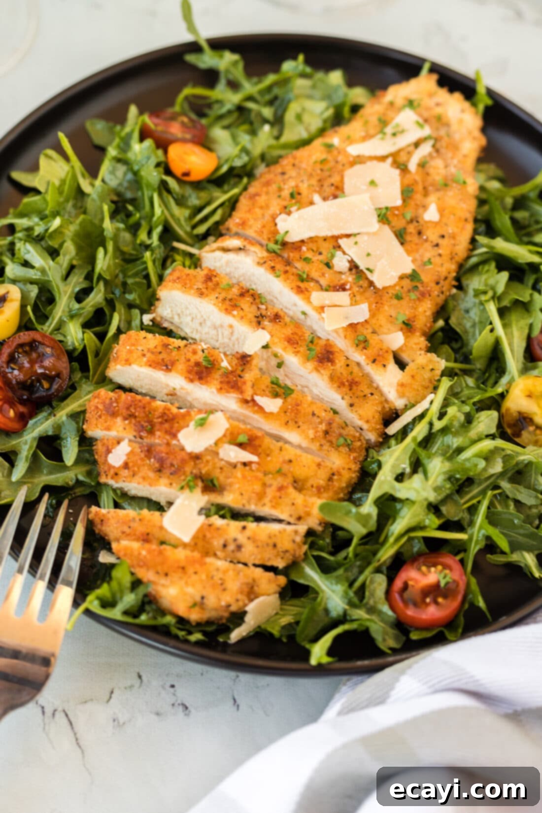 Crispy Chicken Milanese 2 Chicken Milanese on a plate with greens and lemon wedges