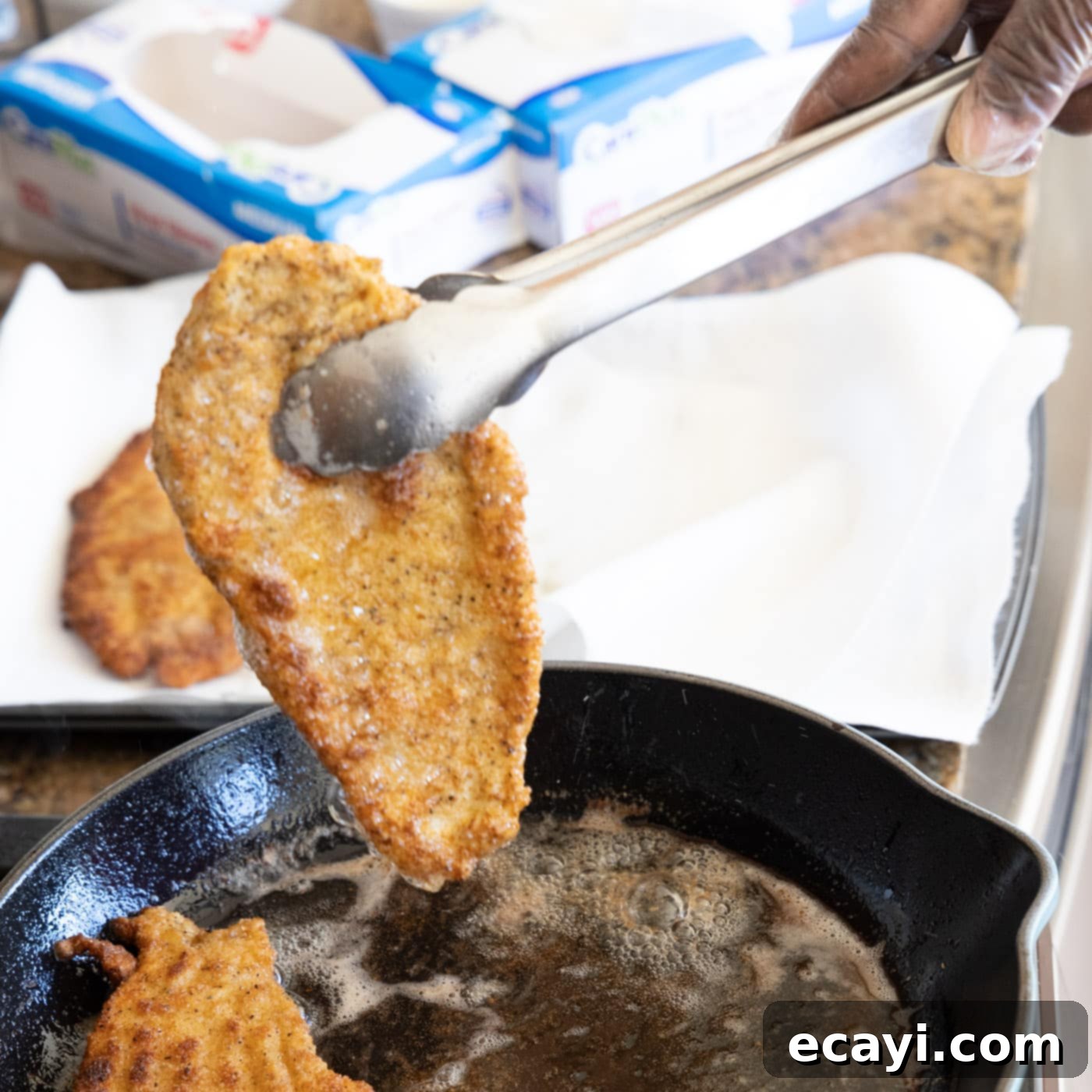 Crispy Chicken Milanese 14 Removing golden brown chicken Milanese from skillet onto paper towels