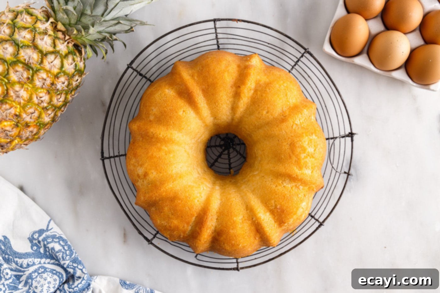 Sunshine Pineapple Pound Cake 11 A freshly baked Pineapple Pound Cake cooling on a wire rack after being removed from the bundt pan.