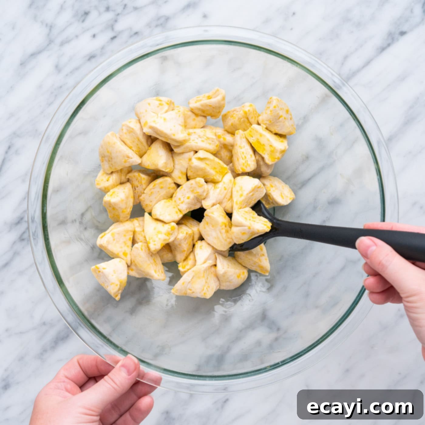 Pizza Bites 6 tossing chopped biscuit dough to olive oil in a bowl
