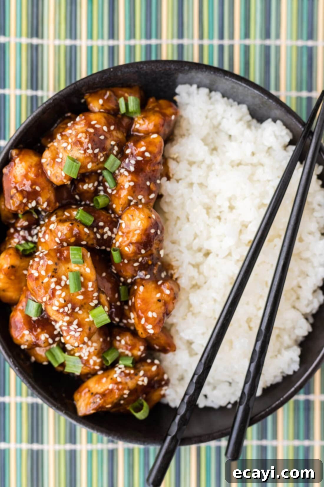 Crispy General Tso Chicken 2 General Tso Chicken in a bowl with rice, garnished with green onions and sesame seeds