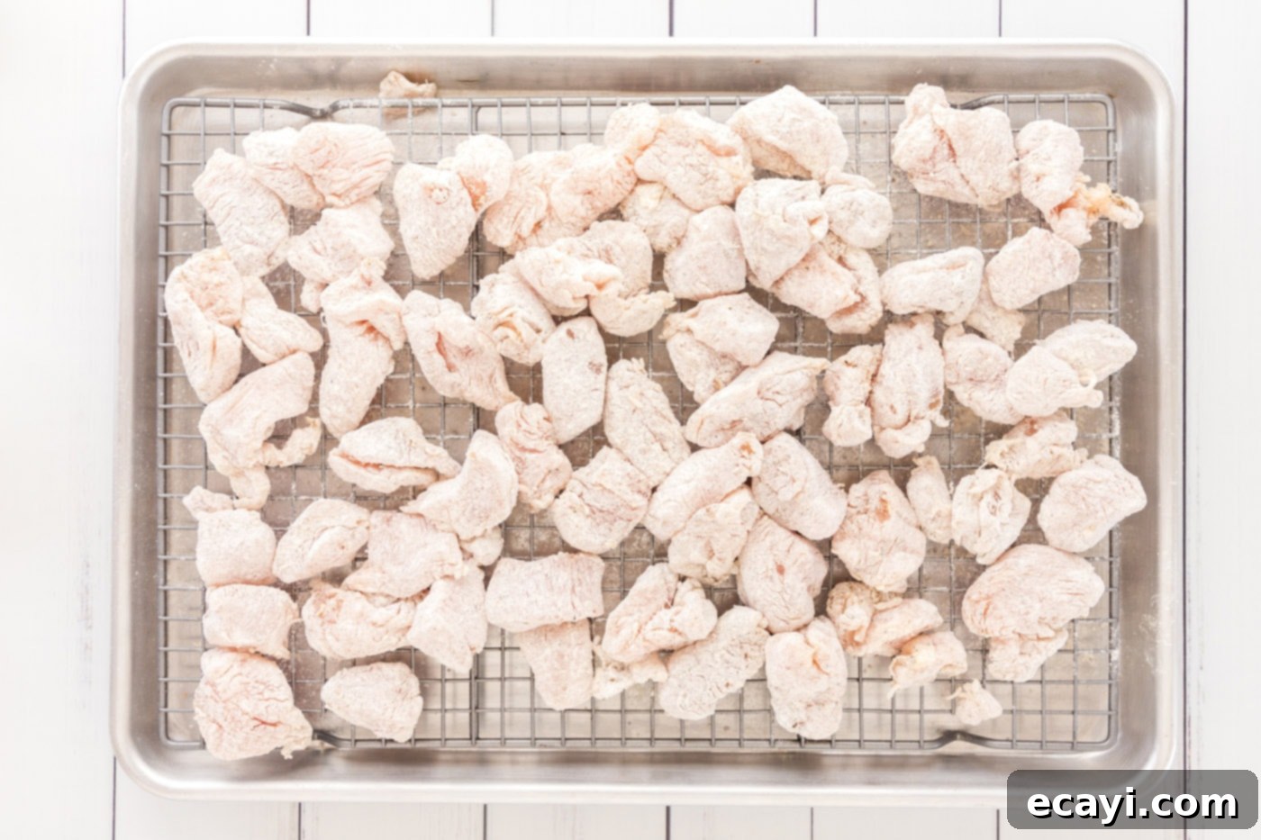 Crispy General Tso Chicken 6 flour-coated chicken pieces neatly arranged on a wire rack