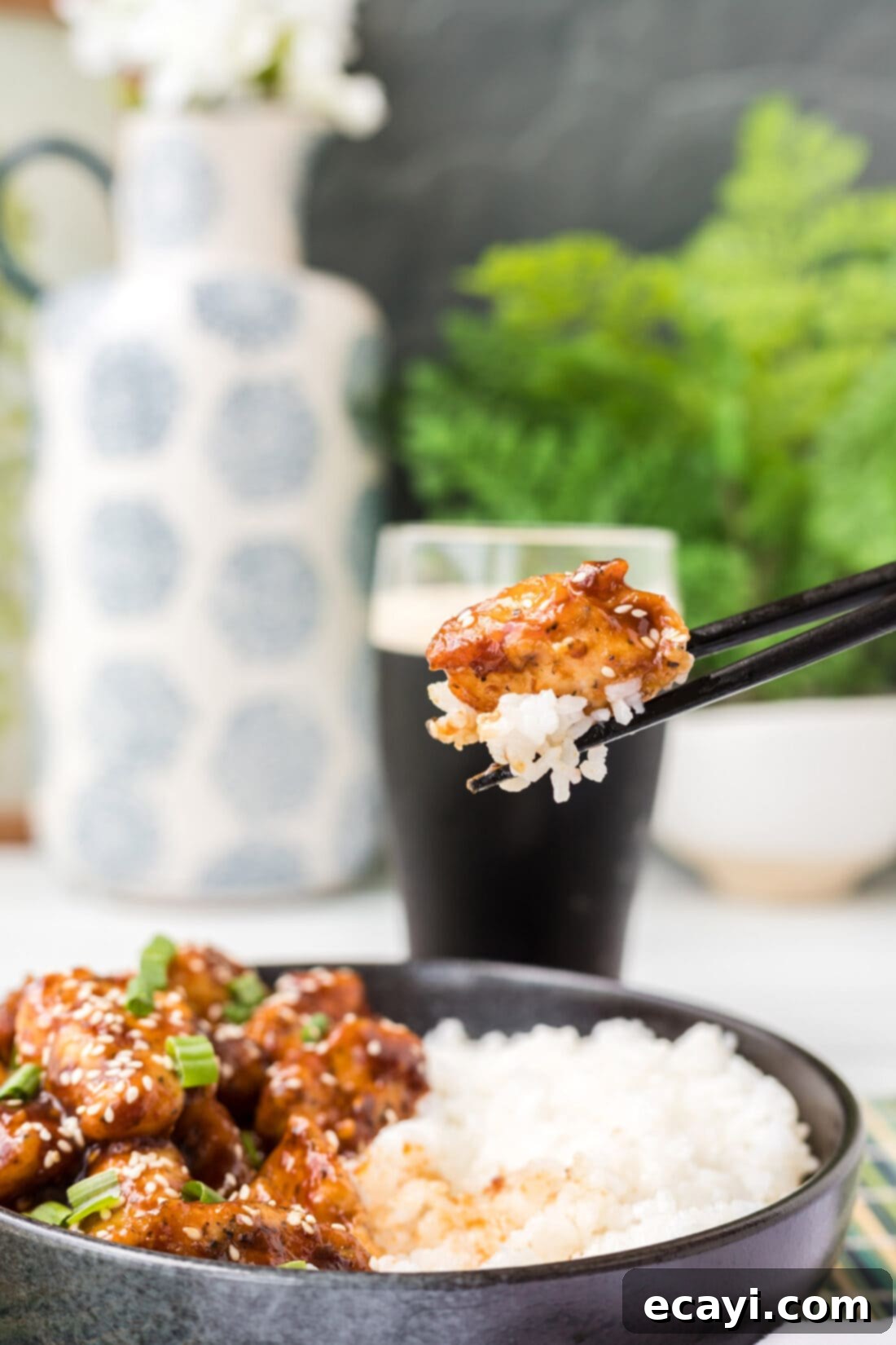 Crispy General Tso Chicken 9 Lifting a piece of General Tso Chicken with chopsticks, showing its crispy texture