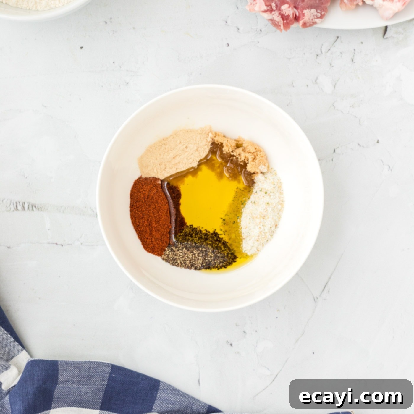 Golden Crispy Pork Chops 5 Olive oil mixed with a blend of garlic salt, smoked paprika, black pepper, onion powder, and brown sugar in a bowl