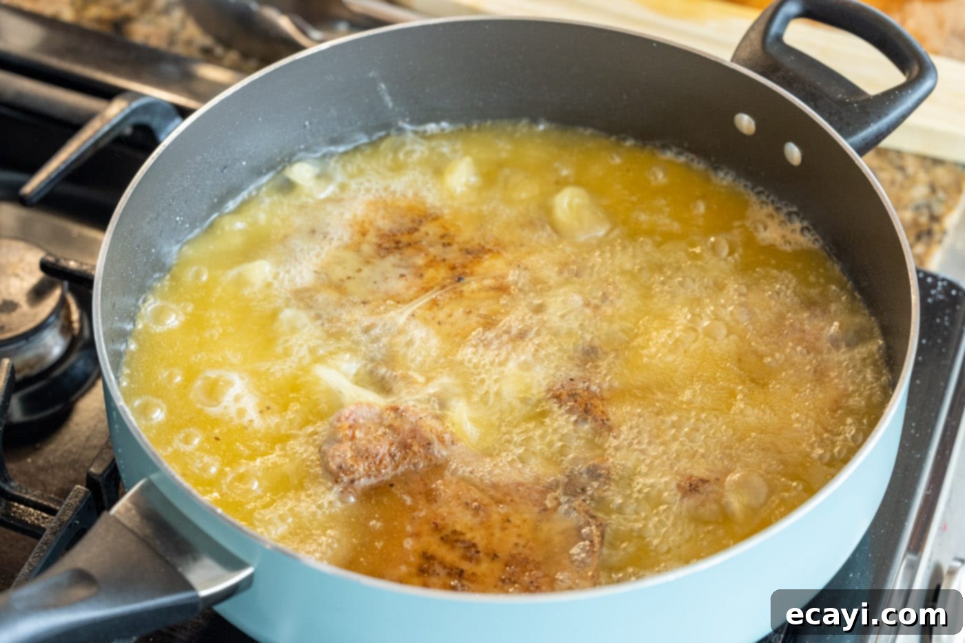 Golden Crispy Pork Chops 10 Multiple pork chops frying to a golden crisp in a cast iron skillet
