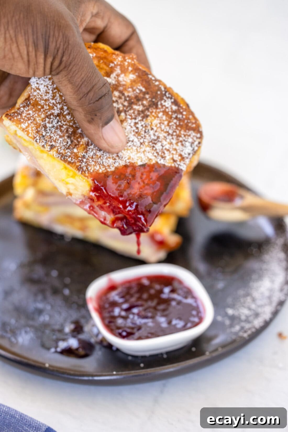Sweet and Savory Monte Cristo Indulgence 3 dipping a Monte Cristo Sandwich in jelly
