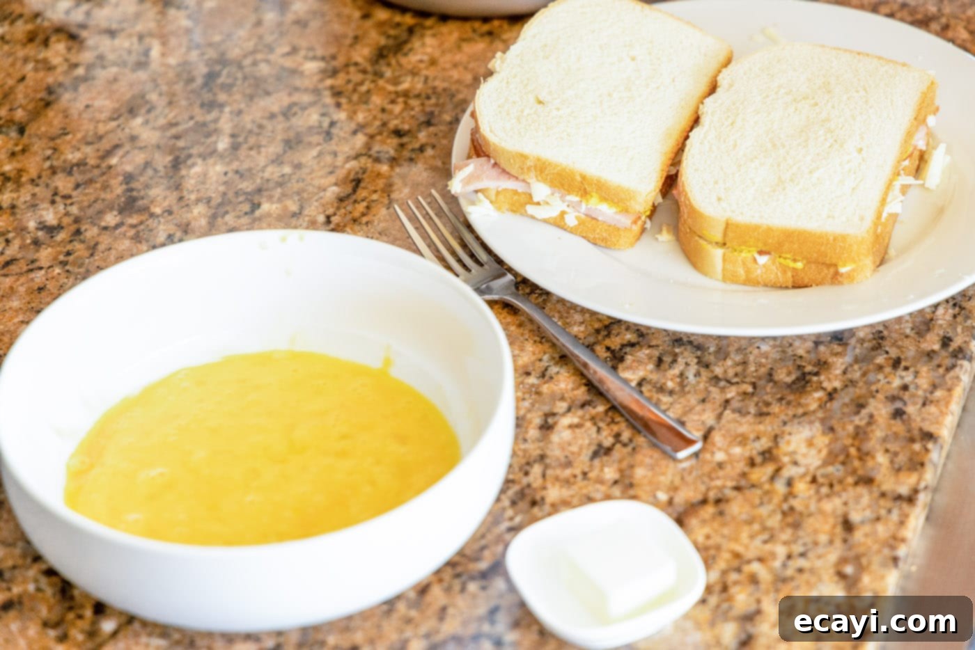 Sweet and Savory Monte Cristo Indulgence 7 whisked eggs in a bowl and monte cristo sandwich on the side