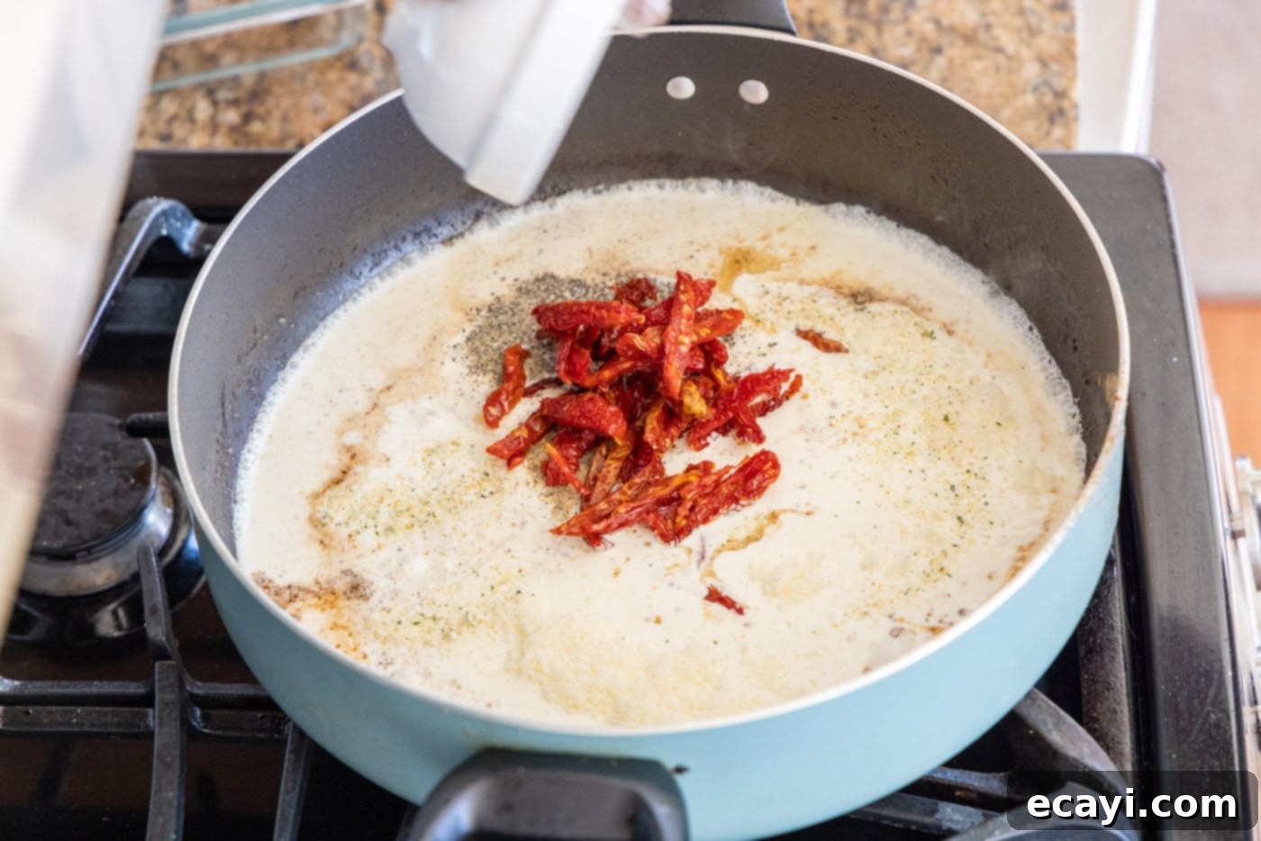The Proposal Chicken 13 adding sun dried tomatoes to heavy cream mixture in skillet