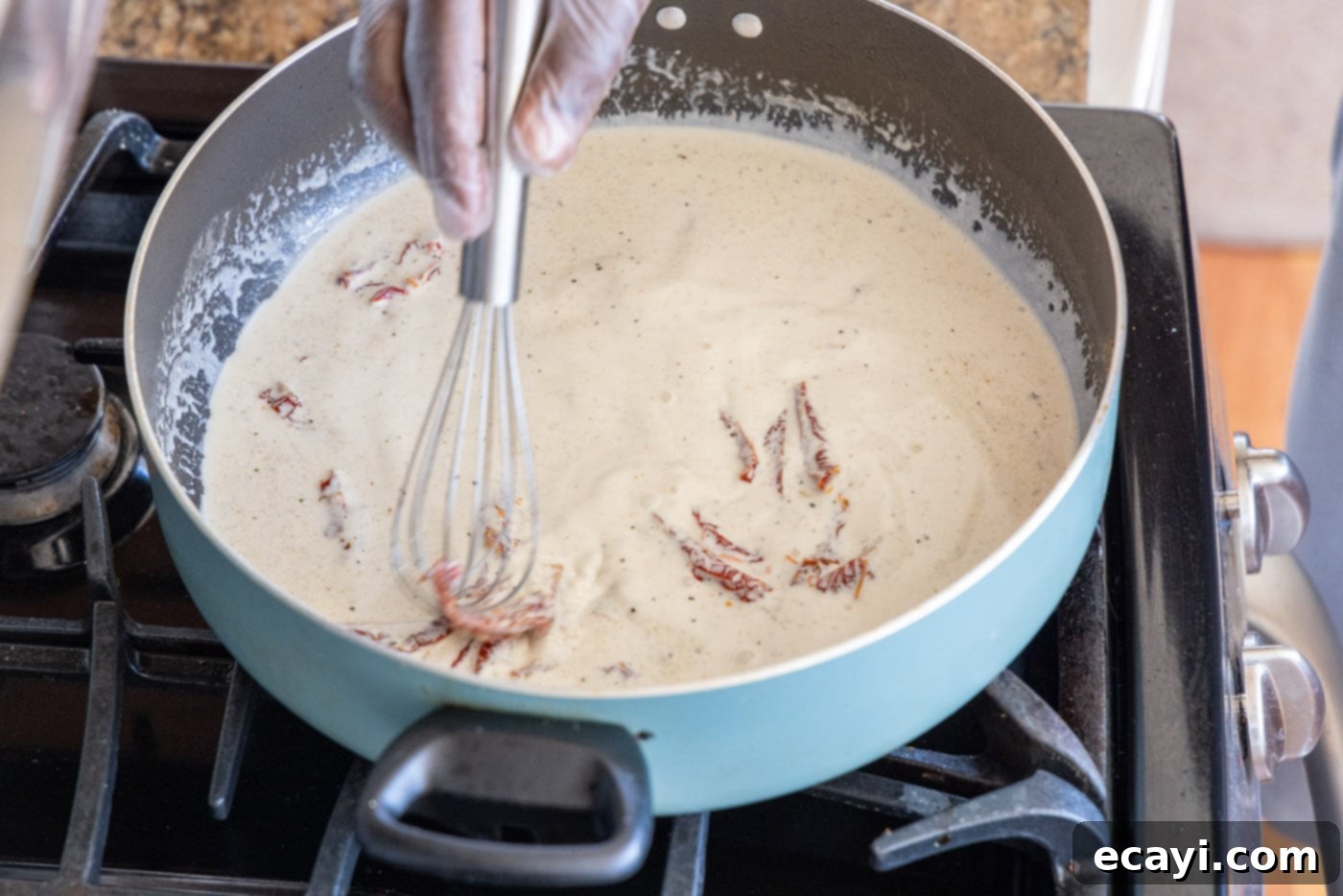 The Proposal Chicken 14 whisking heavy cream mixture in a skillet