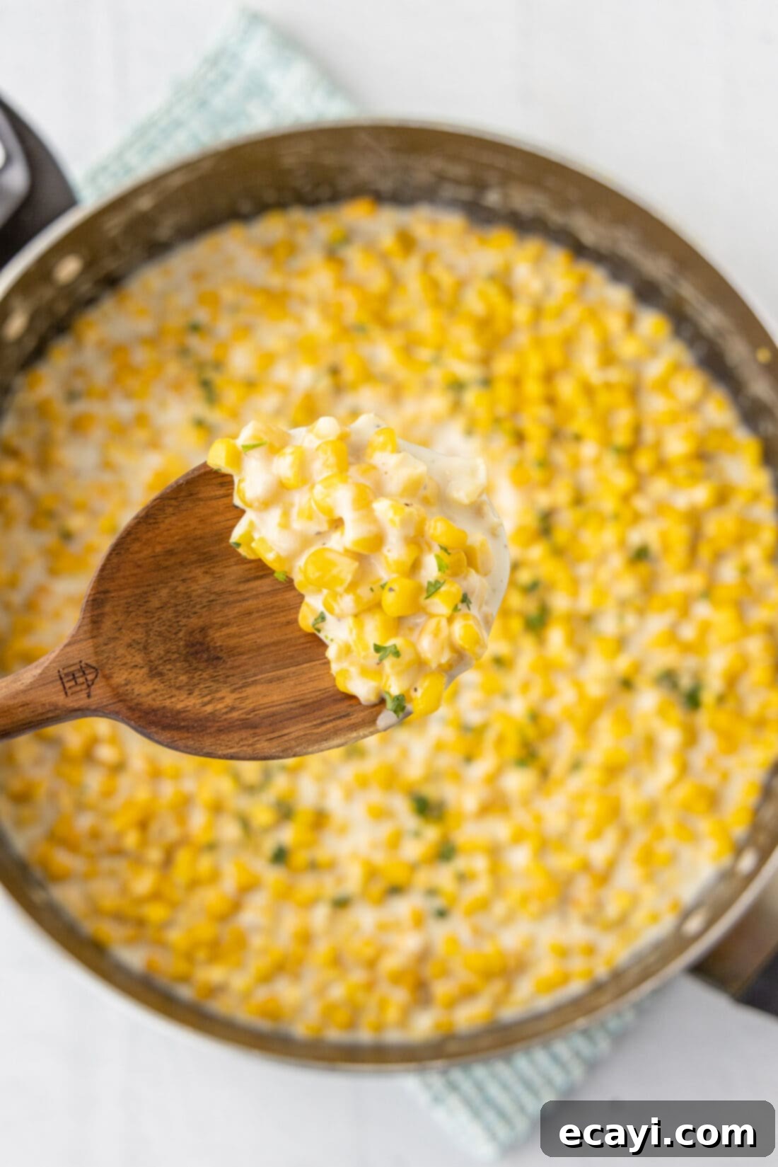 Golden Comfort Corn 3 spoonful of creamy homemade creamed corn being lifted from a bowl