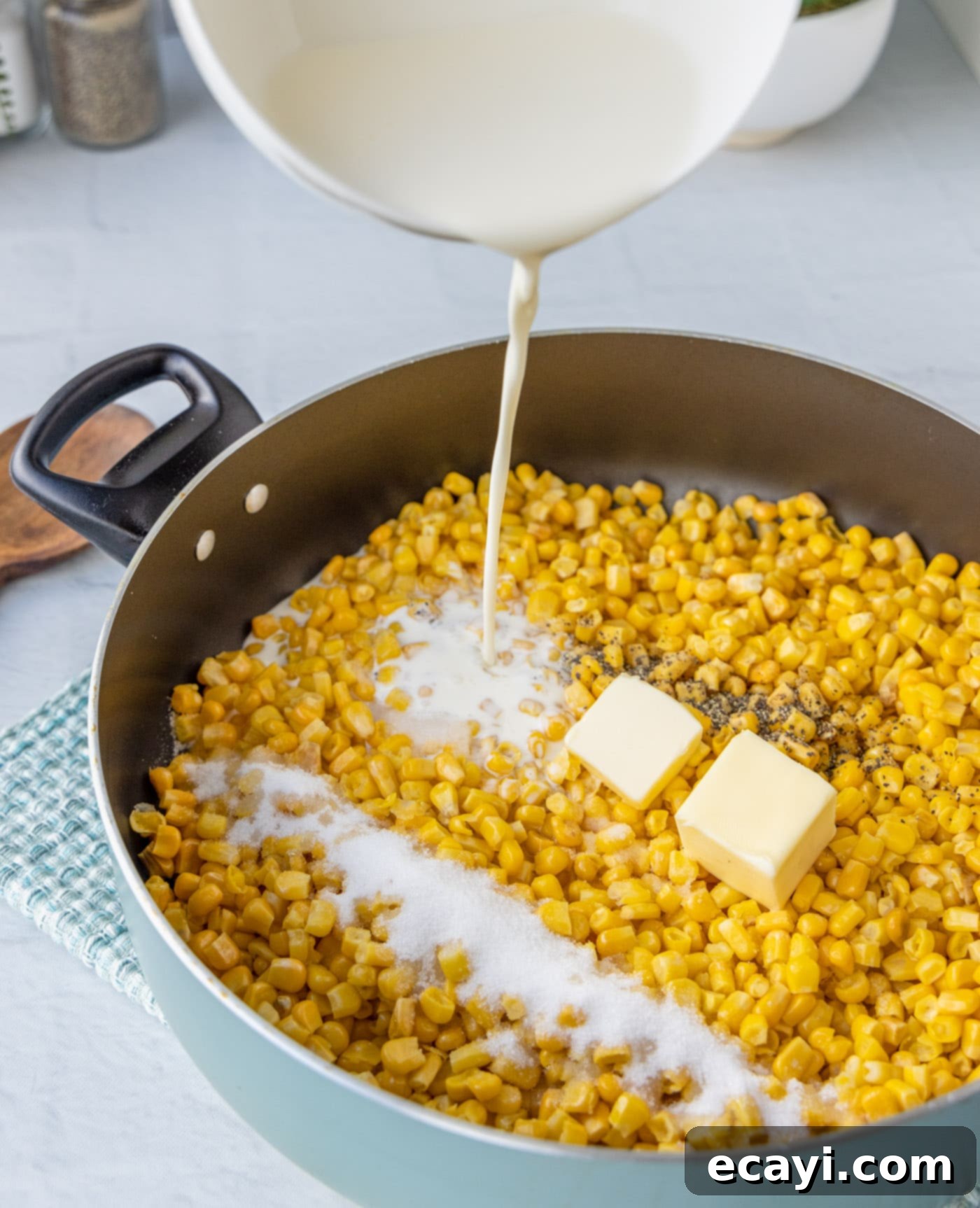Golden Comfort Corn 6 pouring heavy cream into saucepan with corn mixture