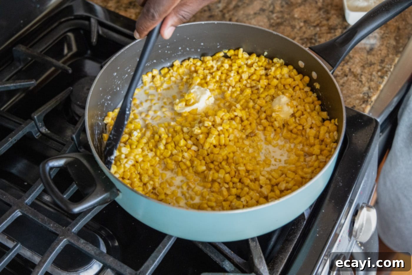 Golden Comfort Corn 7 mixing creamed corn in a skillet, stirring to combine