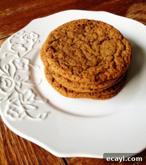 Sugar Topped Molasses Spice Cookies - AmandasCookin.com A stack of sugar topped molasses spice cookies on a white plate.