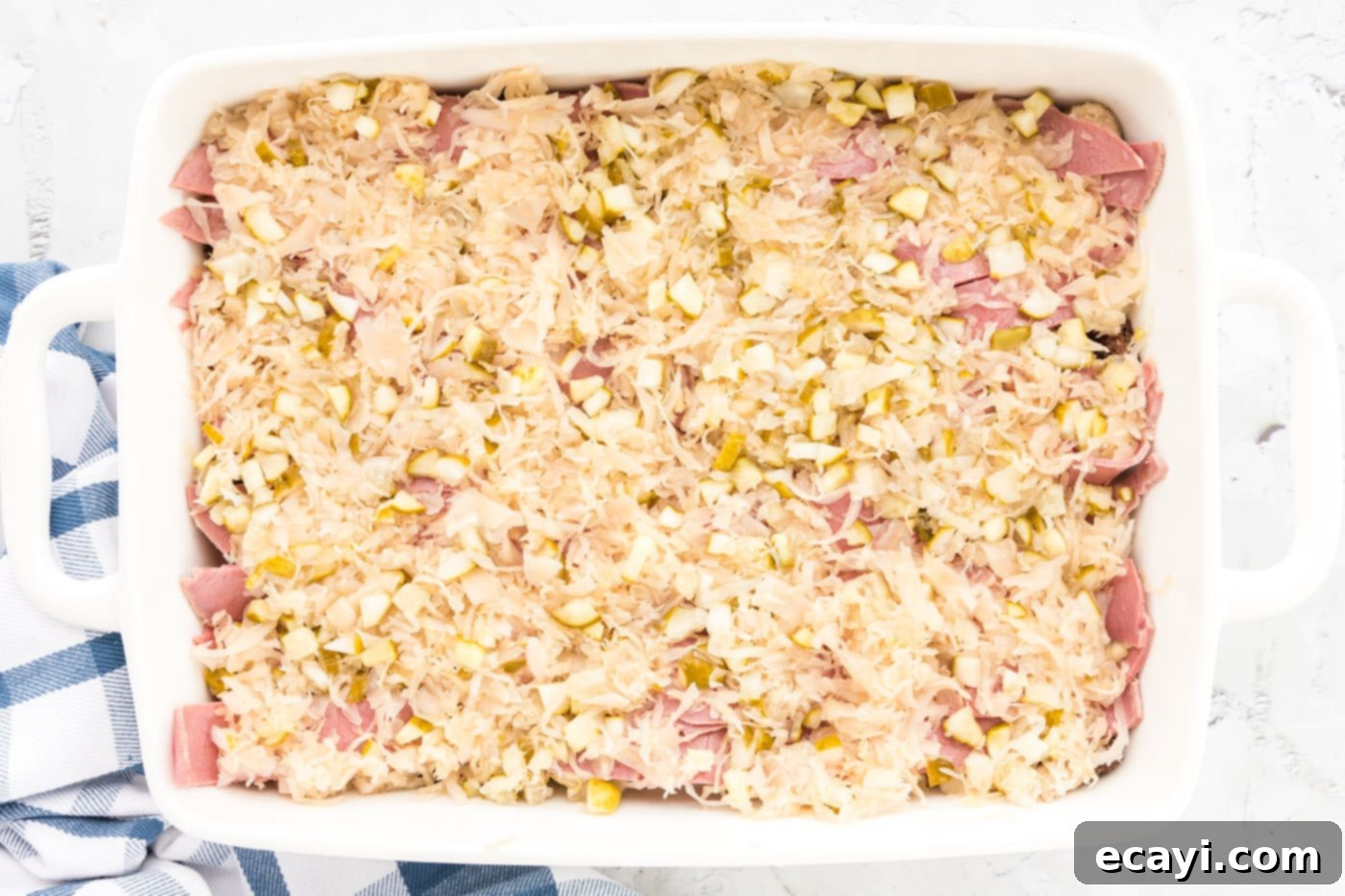 Ultimate Reuben Casserole Bake 11 The sauerkraut and pickle mixture spread evenly over the layer of sliced corned beef in the casserole dish.