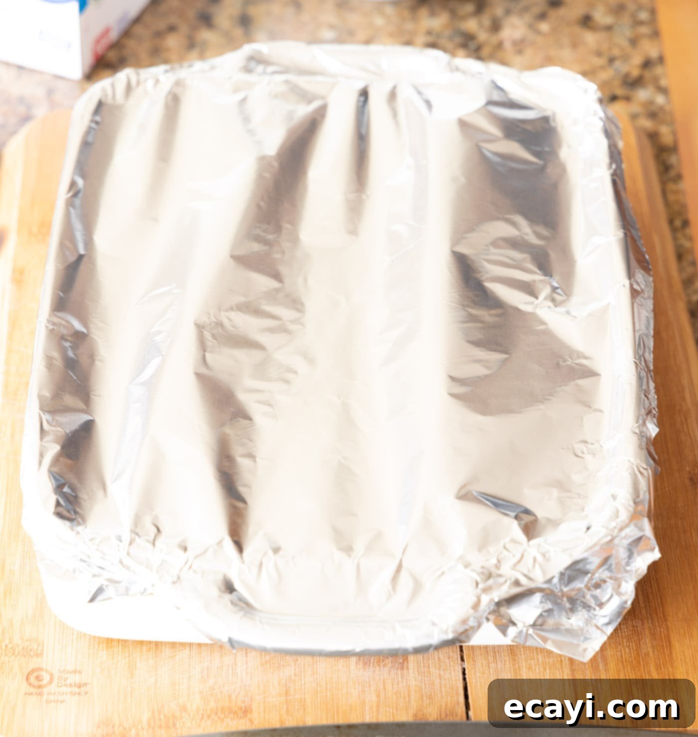 Ultimate Reuben Casserole Bake 16 A baking dish filled with Reuben casserole layers, tightly covered with aluminum foil, ready for the oven.
