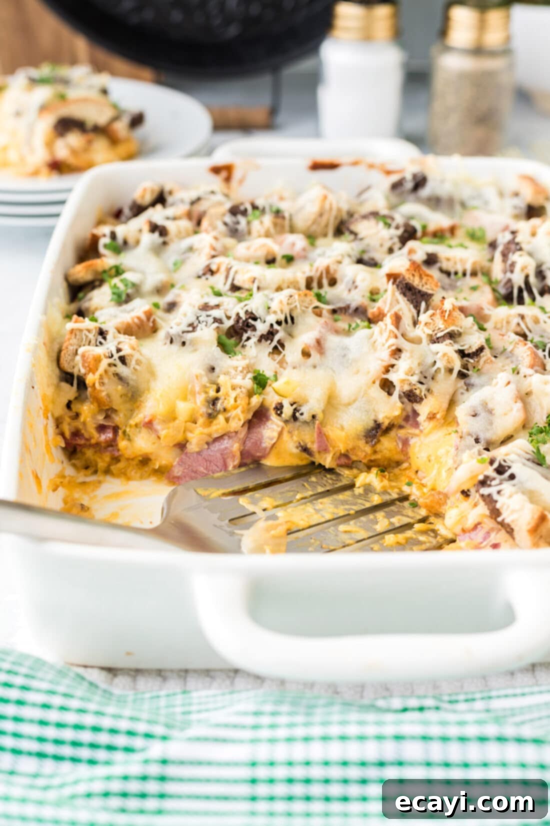 Ultimate Reuben Casserole Bake 20 A spatula scooping a generous portion of freshly baked Reuben Casserole from a pan, showing the golden-brown top and rich, cheesy interior.