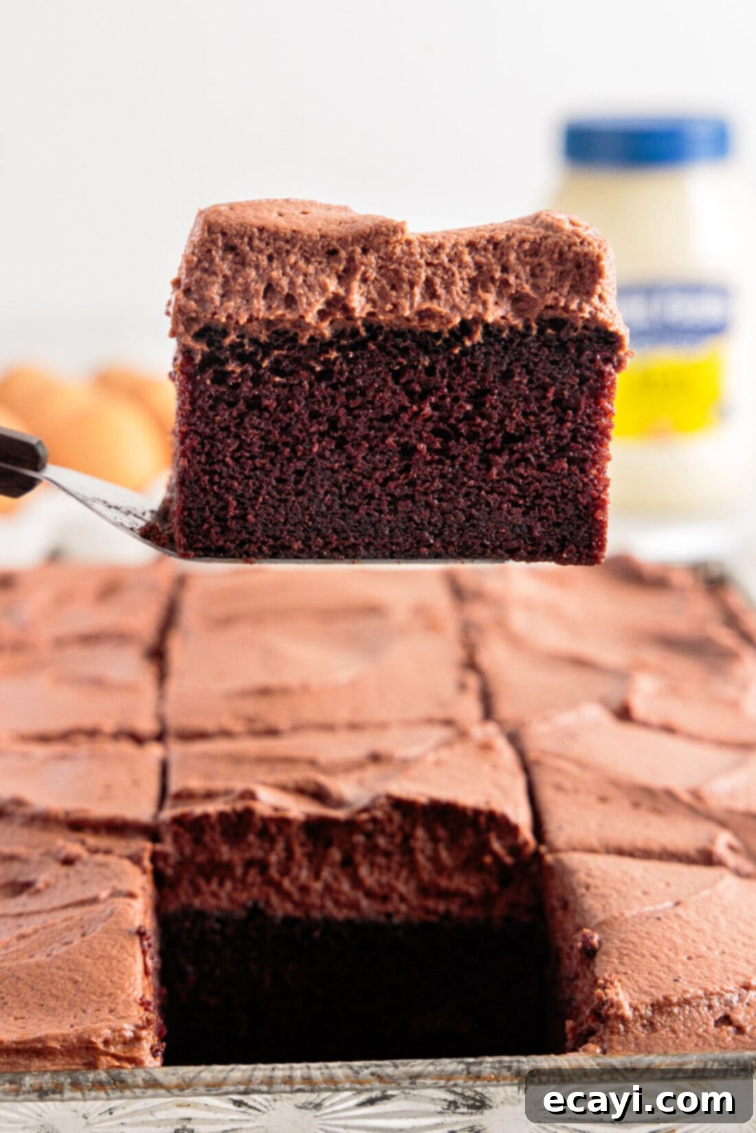 Velvet Moisture Cake 2 spatula lifting a piece of Mayonnaise Cake, showcasing its moist texture and rich frosting