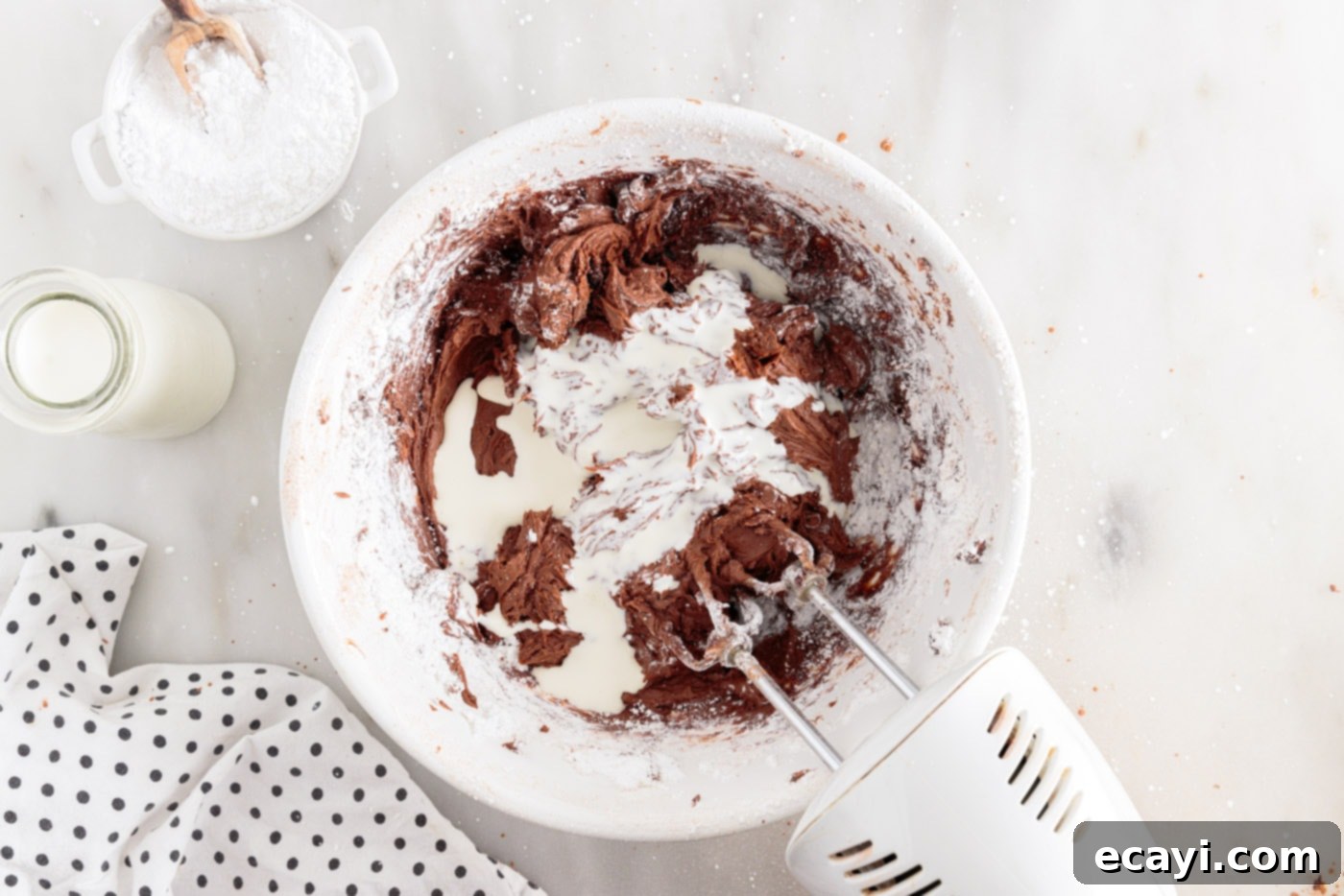 Velvet Moisture Cake 11 a hand mixer expertly incorporating all chocolate frosting ingredients until smooth and fluffy