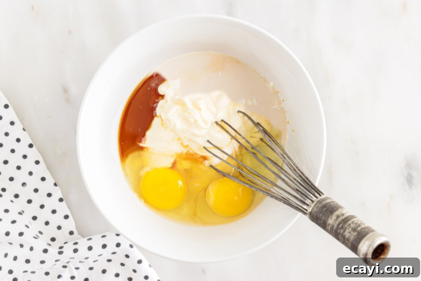 Velvet Moisture Cake 6 wet ingredients including eggs, milk, mayonnaise, and vanilla being whisked together in a separate bowl