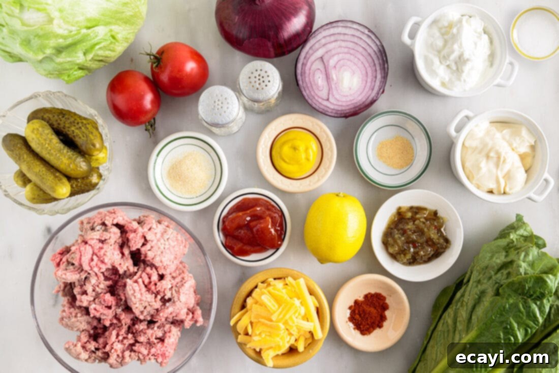 Deconstructed Big Mac Salad 4 ingredients for Big Mac Salad laid out, including ground beef, lettuce, cheese, and dressing components