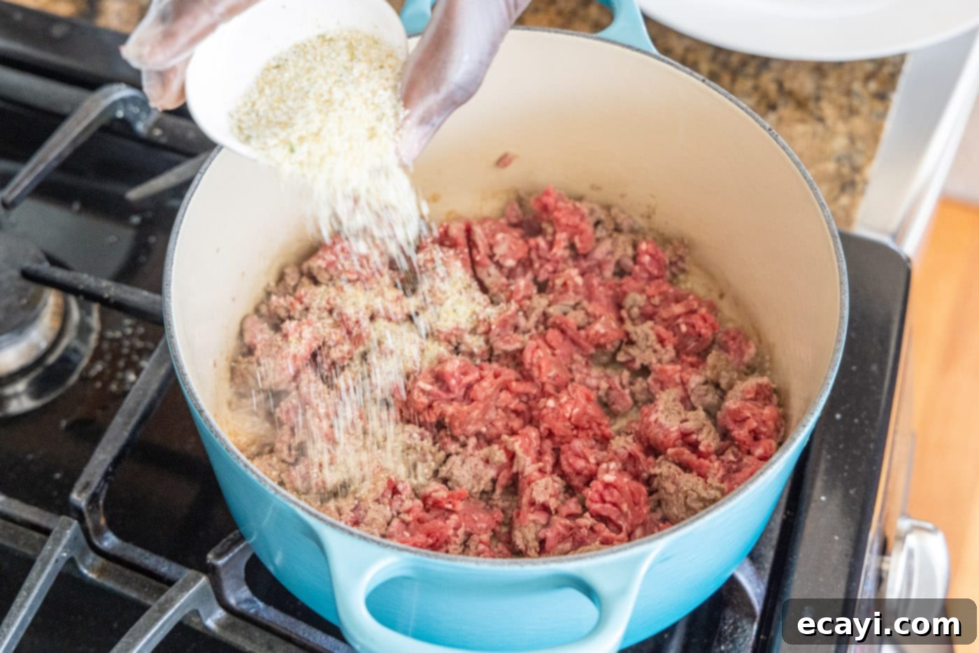 Soulful Louisiana Rice 5 Adding garlic salt to ground beef in a Dutch oven, preparing for browning.