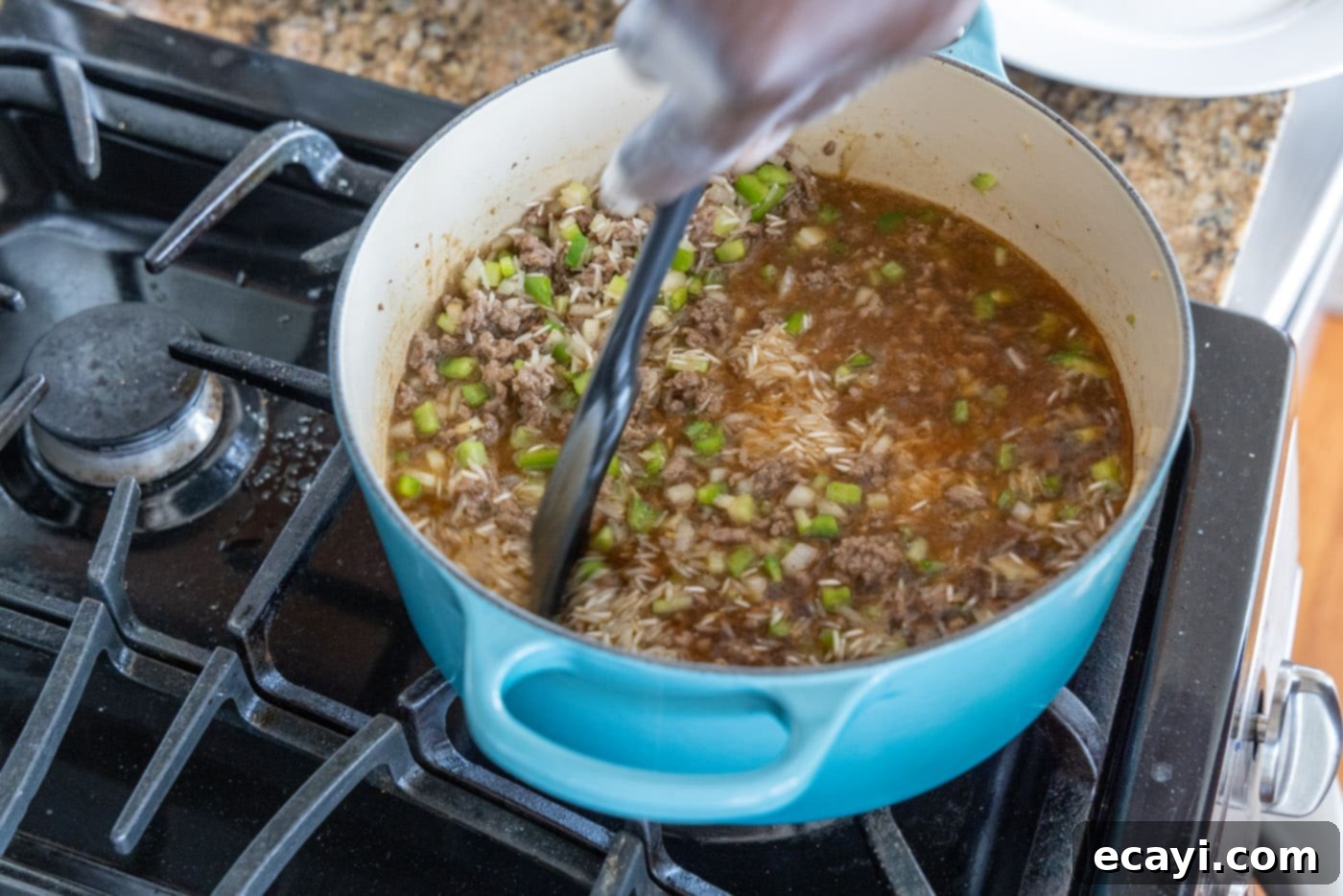 Soulful Louisiana Rice 10 Mixing the dirty rice ingredients evenly in a Dutch oven before covering to cook.
