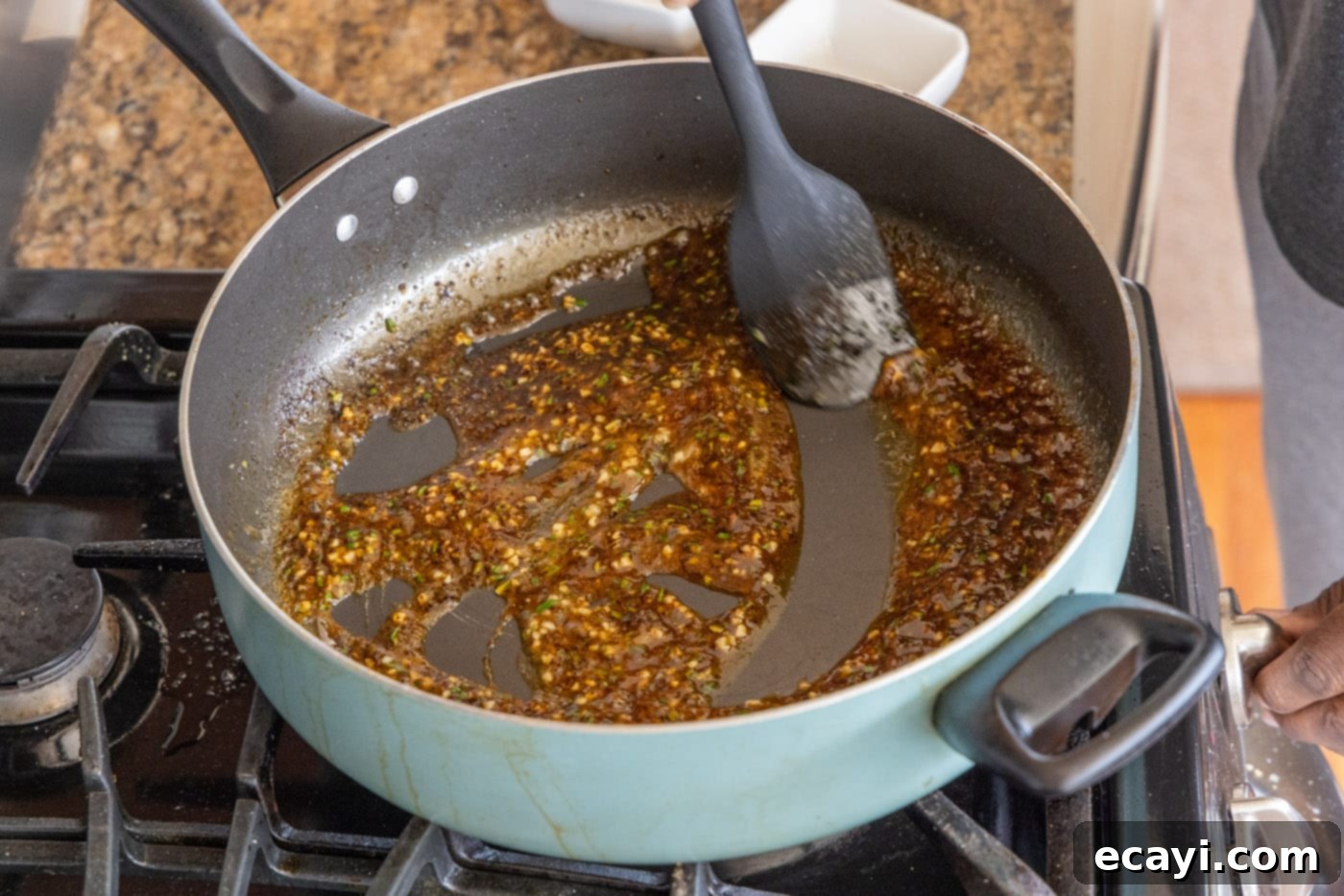 Succulent Veal Chops 12 A spoon stirring the fragrant pan sauce in the skillet, showing the rosemary, garlic, and lemon juice blending to create a rich reduction.