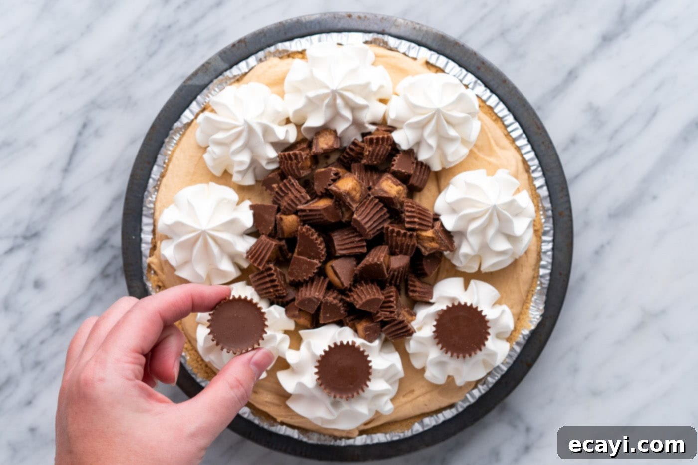 Peanut Butter Perfection Pie 14 adding peanut butter cups on top of piped whipped cream rosettes