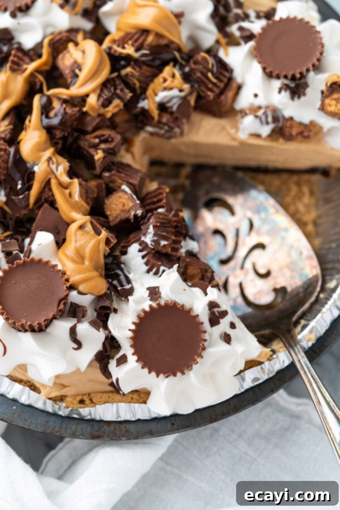 Peanut Butter Perfection Pie 3 A spatula poised to scoop a piece of the delightful Reese's Pie, showcasing the thick peanut butter filling and rich chocolate layer.