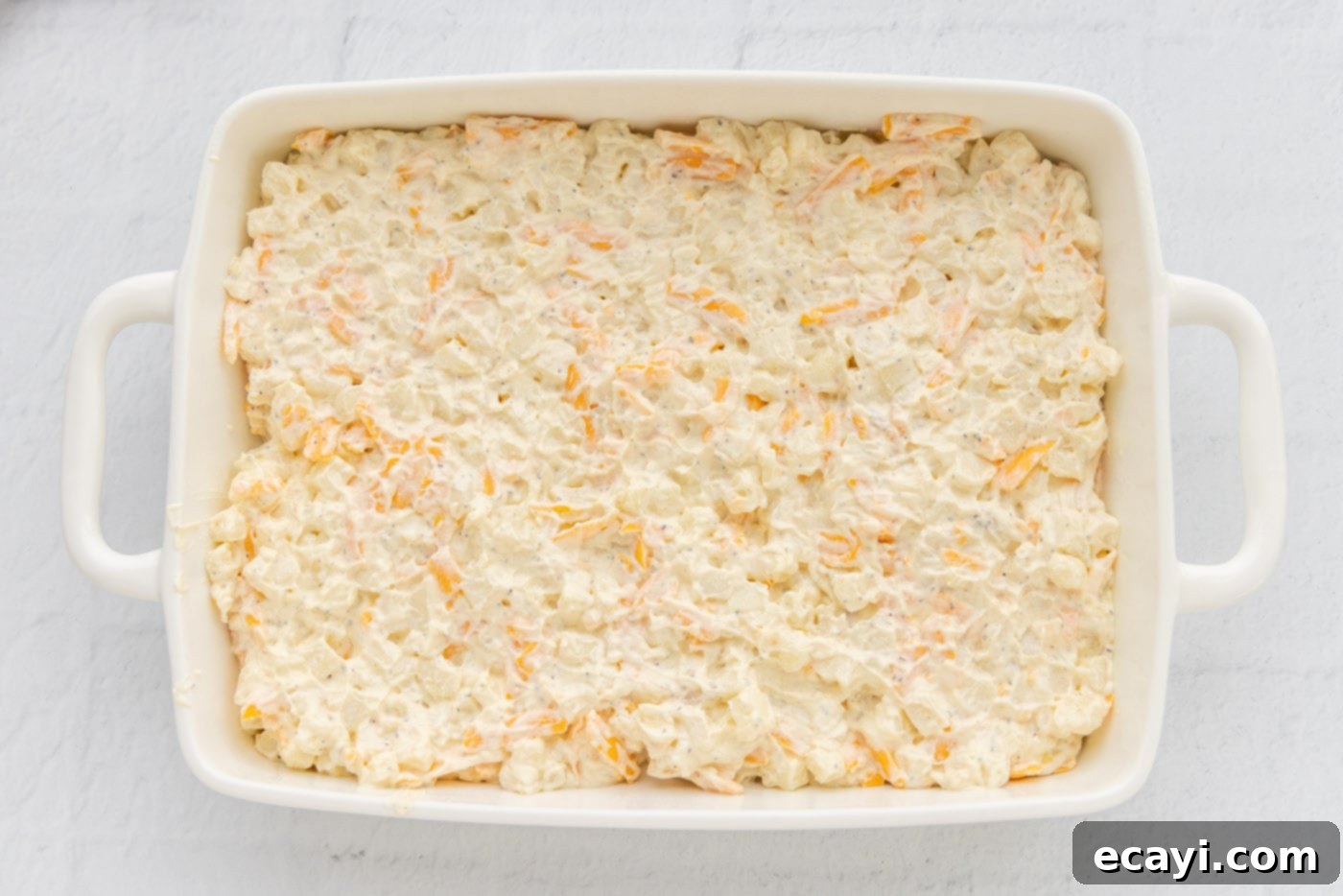 Heartwarming Potato Casserole 14 funeral potatoes in a casserole dish ready for topping