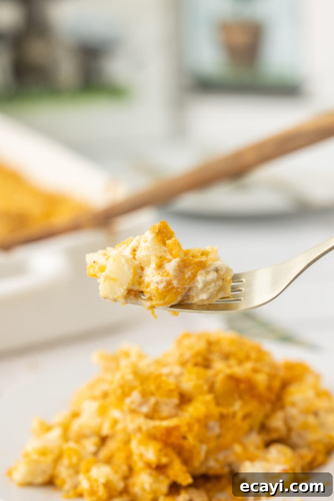 Heartwarming Potato Casserole 16 fork taking a scoop of warm funeral potatoes with crispy topping