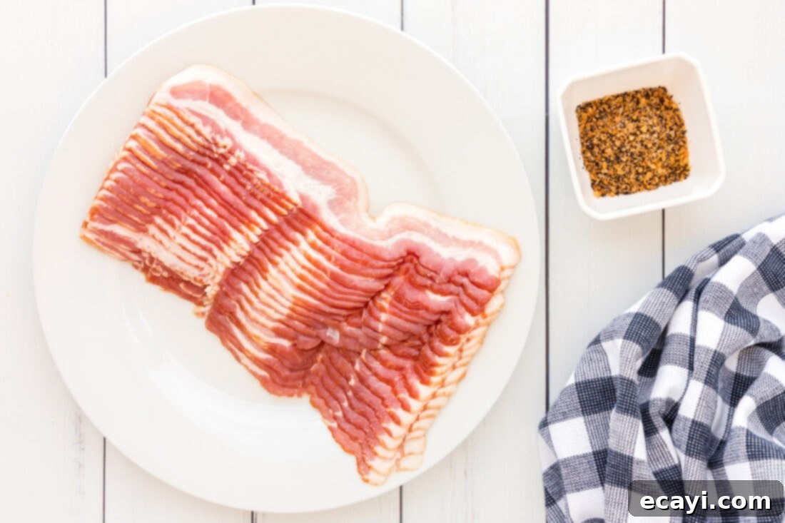 Perfect Crispy Oven Bacon 4 Ingredients for How to Cook Bacon in the Oven: raw bacon slices and a jar of Montreal Steak seasoning