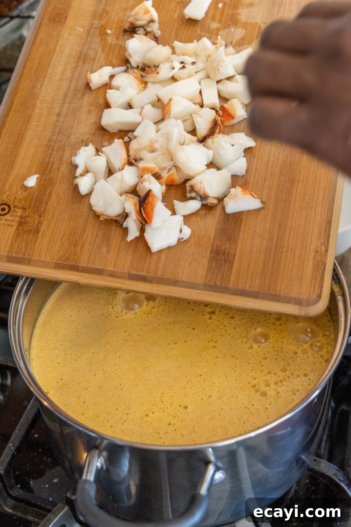 Rich Lobster Bisque 11 chopped lobster added to a pot of creamy bisque, ready to be warmed through