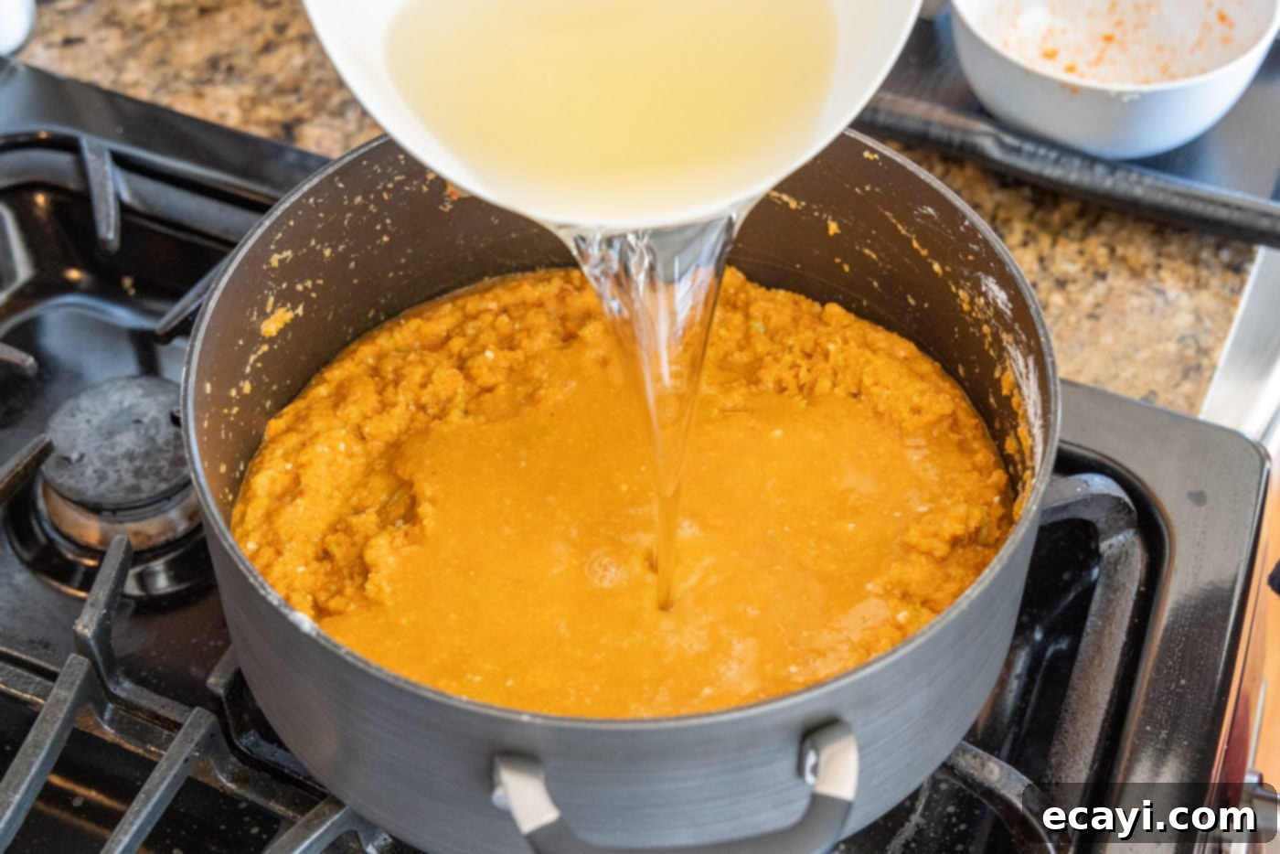 Rich Lobster Bisque 8 pouring dry white wine into the lobster bisque base, stirring to deglaze