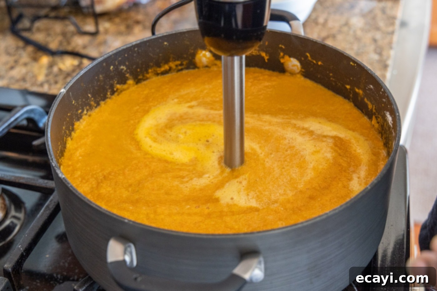 Rich Lobster Bisque 10 blending heavy cream into the lobster soup with an immersion blender for a smooth consistency