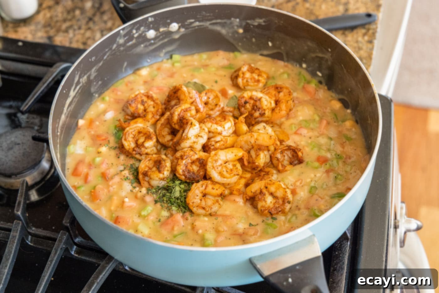 Authentic Cajun Shrimp Etouffee 11 Partially cooked shrimp, bay leaves, and thyme added to the rich etouffee gravy in a skillet.