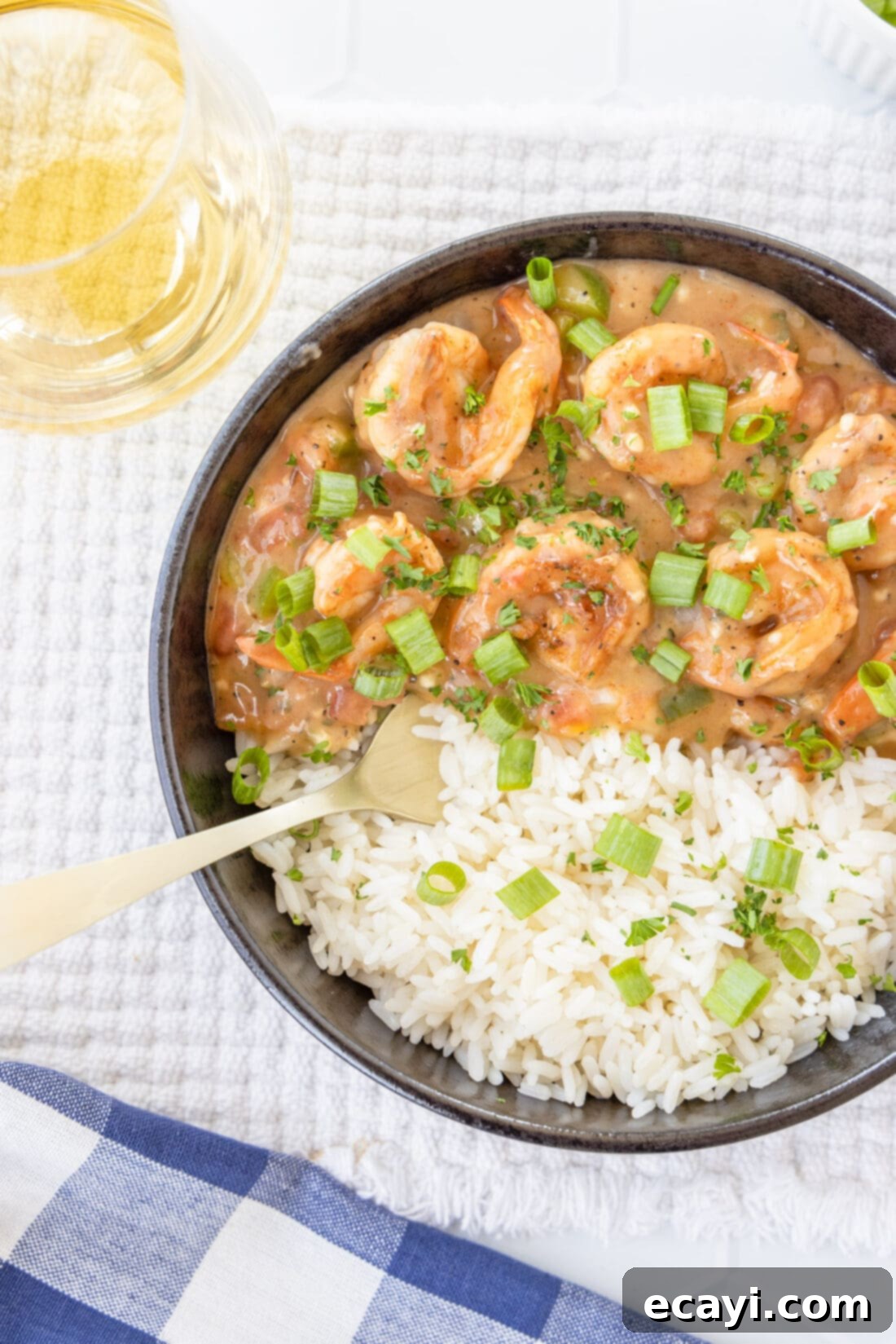 Authentic Cajun Shrimp Etouffee 3 A bowl of shrimp etouffee served over fluffy white rice, garnished with fresh parsley.