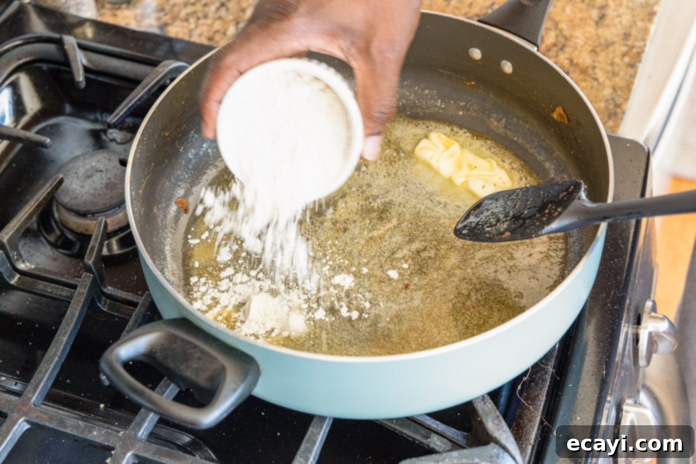 Authentic Cajun Shrimp Etouffee 7 Flour being added to melted butter in a skillet, beginning to form a roux.