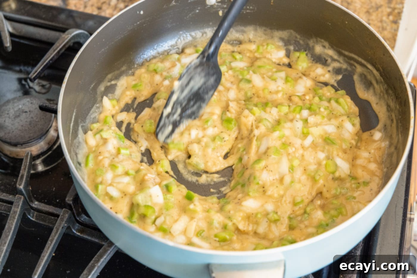 Authentic Cajun Shrimp Etouffee 9 Various liquids and seasonings being mixed into the roux and vegetables in a skillet to form the etouffee gravy.