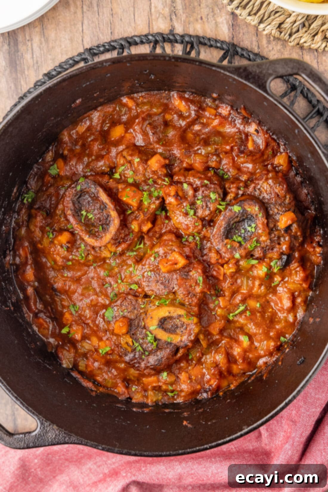 Exquisite Veal Osso Buco 2 Veal Osso Bucco in a dutch oven, showcasing the rich braising liquid and tender meat