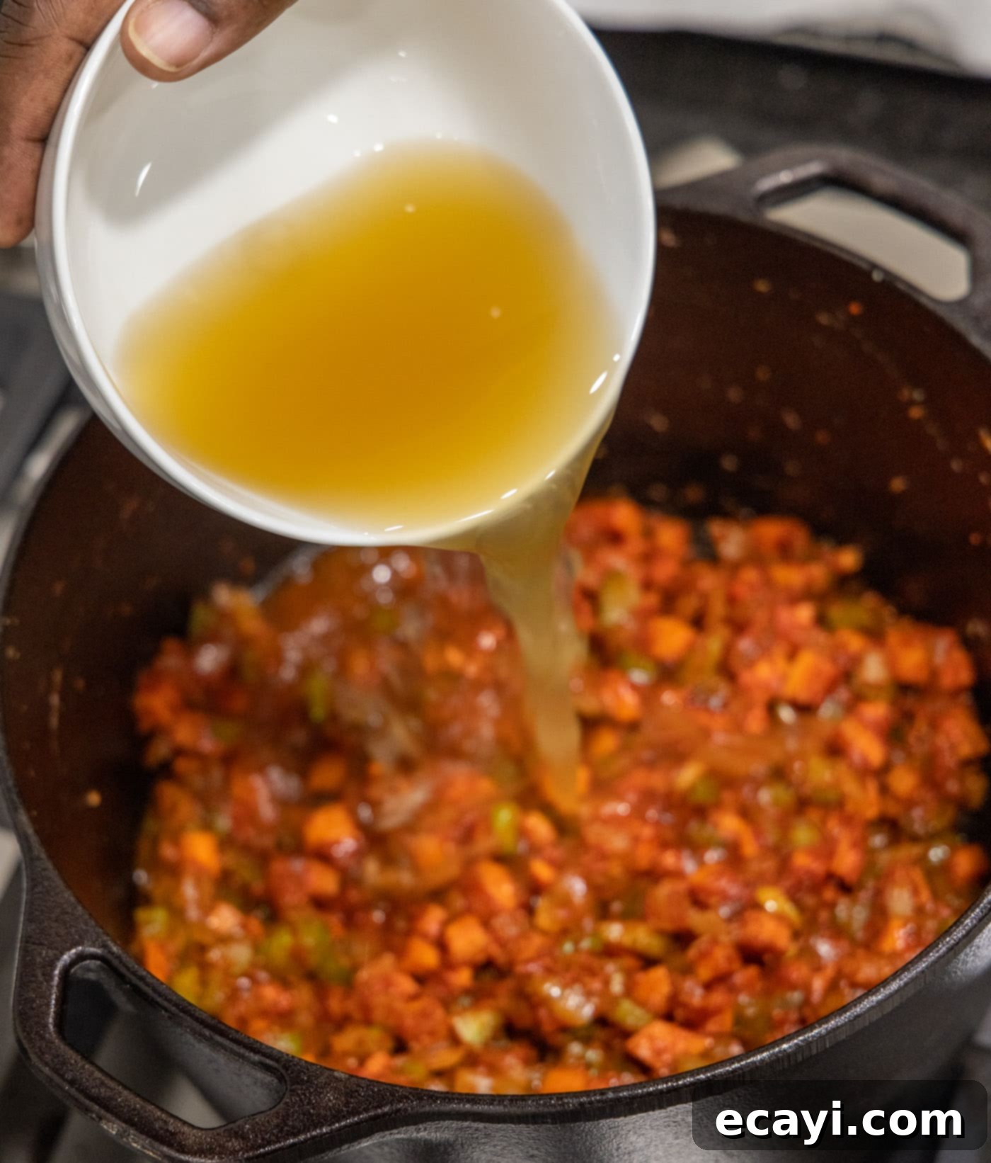 Exquisite Veal Osso Buco 11 pouring chicken broth into the veal osso buco mixture