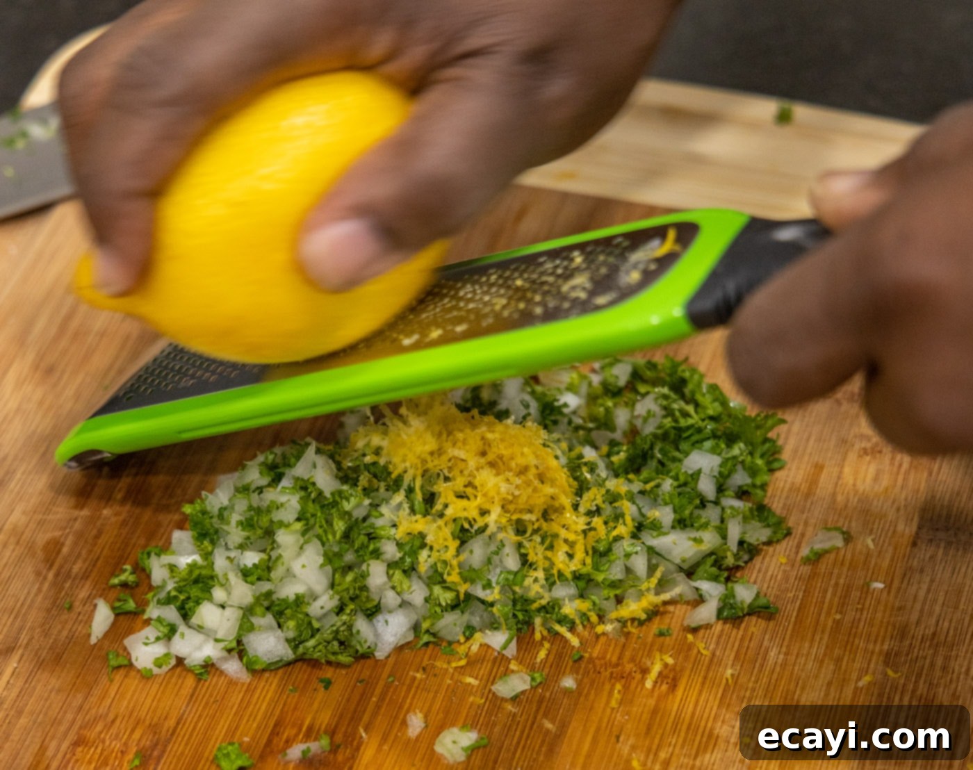 Exquisite Veal Osso Buco 16 grating lemon zest over chopped onion and parsley for gremolata
