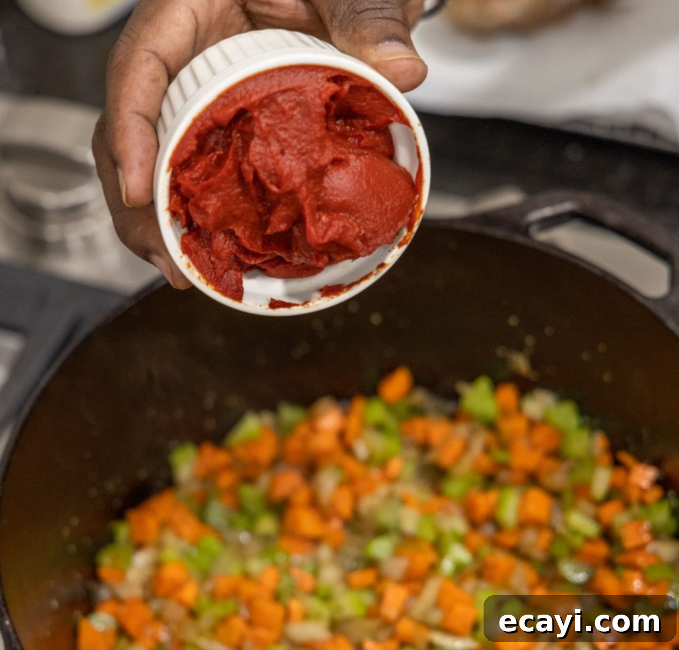 Exquisite Veal Osso Buco 10 adding tomato paste to sautéed celery, onion, and carrots in a dutch oven