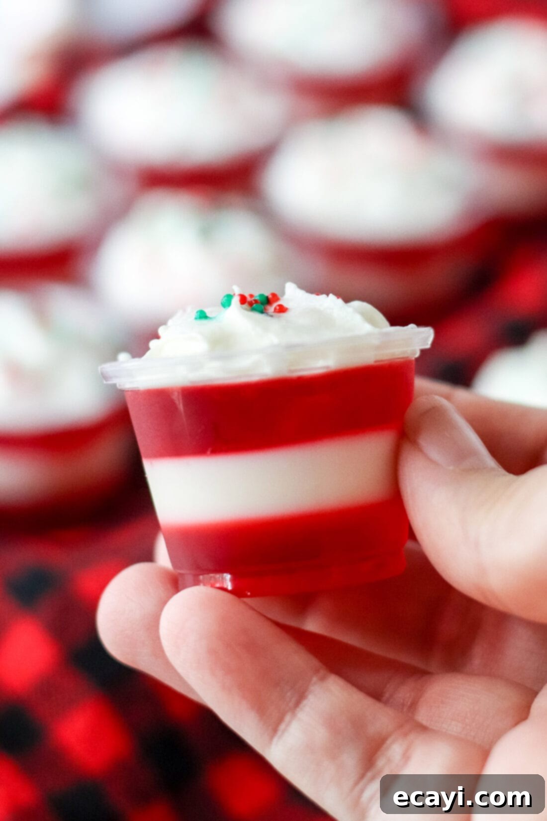 Peppermint Swirl Shooters 2 holding a Candy Cane Jello Shot, featuring distinct red and white layers, ready for a festive holiday party