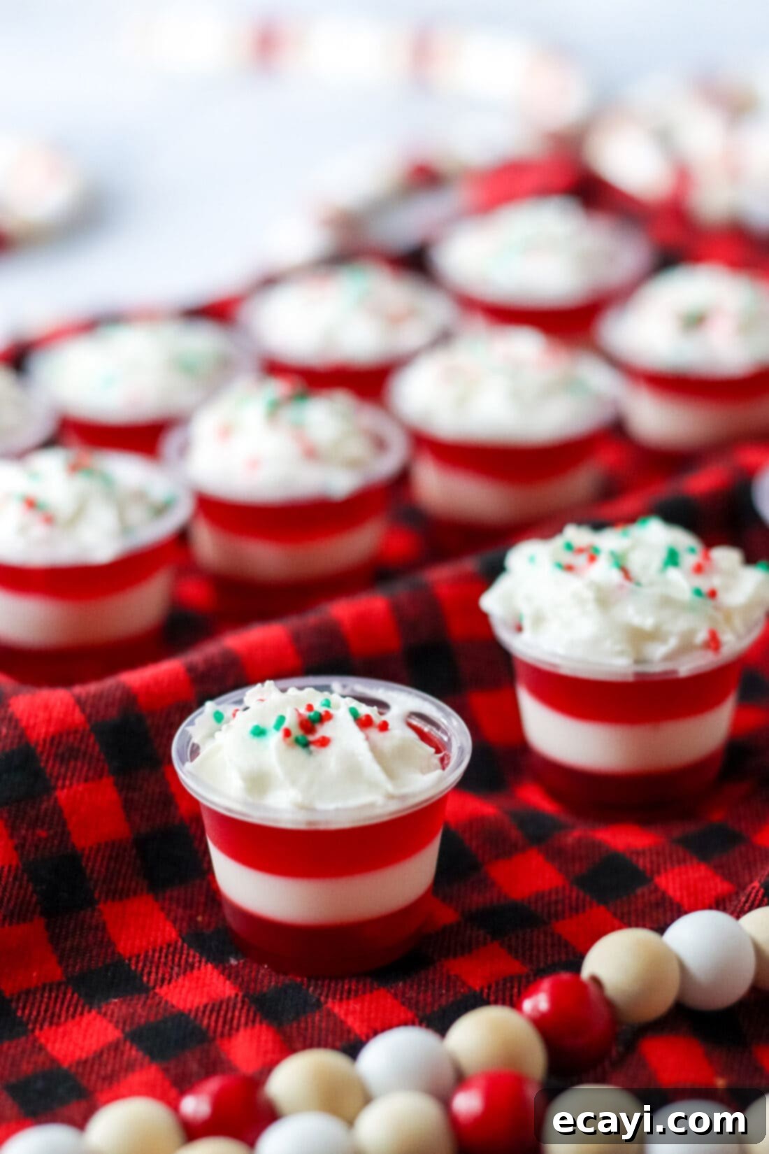 Peppermint Swirl Shooters 5 Candy Cane Jello Shots arranged on festive red and black fabric, ready for a Christmas party